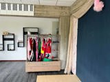Theaterkamer met een rek vol verkleedkleren.